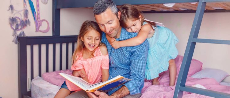 Father reading to his daughters