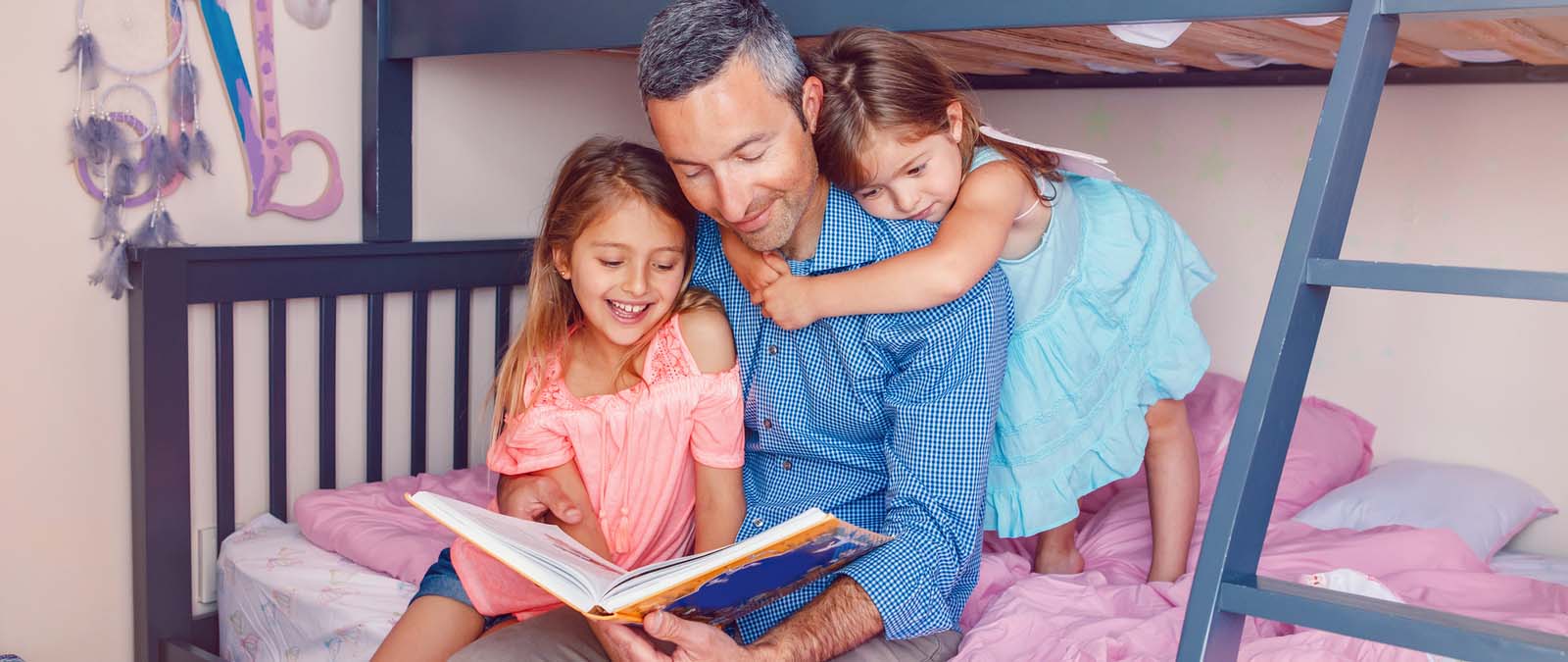 Father reading to his daughters