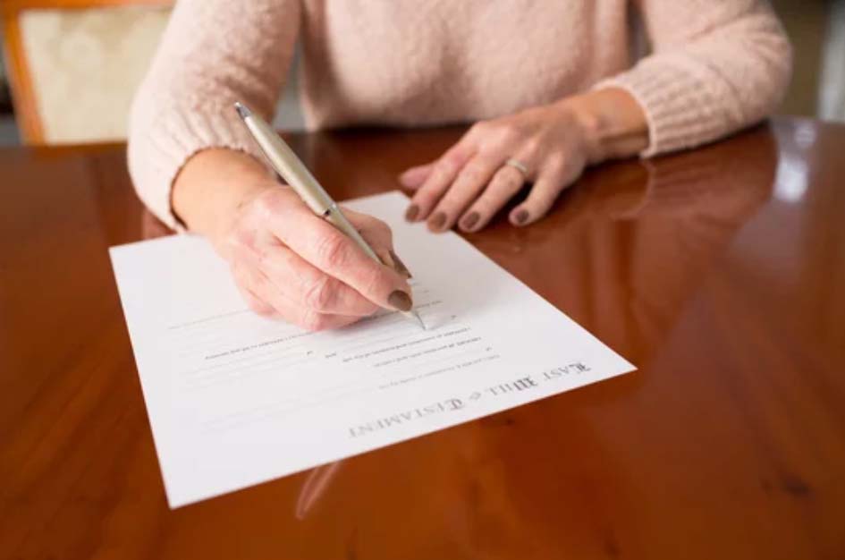 Close up of senior woman signing a will