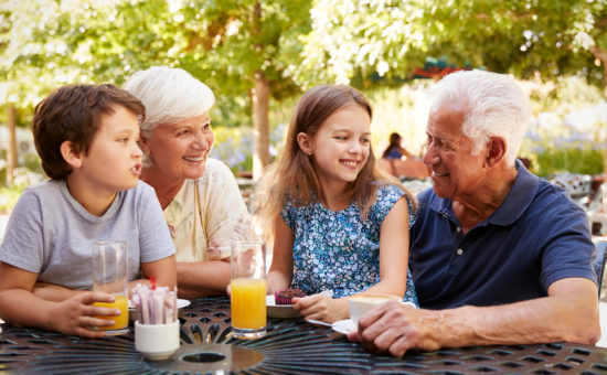 Grandparents And Grandchildren Enjoying Snack At Outdoor CafÅ½