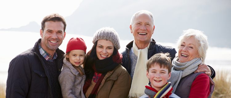 Multi Generation Family In Sand Dunes On Winter Beach