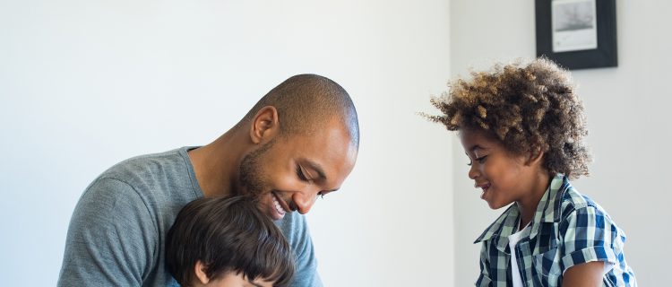 Young black father helping his boys with homework.