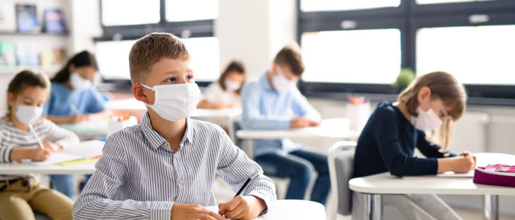 Boy Wearing a Mask at Desk in Classroom